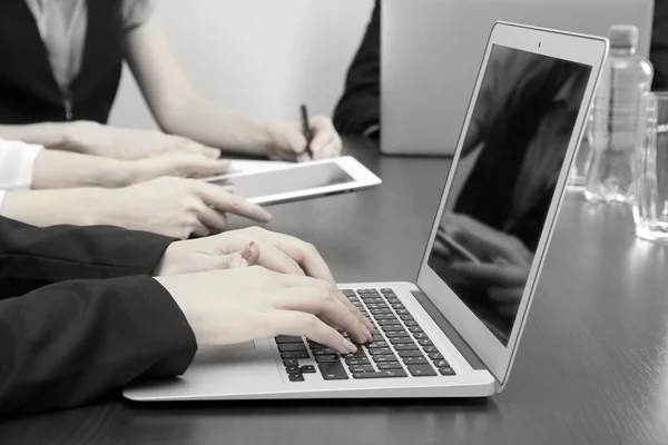 Mãos femininas com tablet digital no fundo do escritório em tons de cinza — Fotografia de Stock