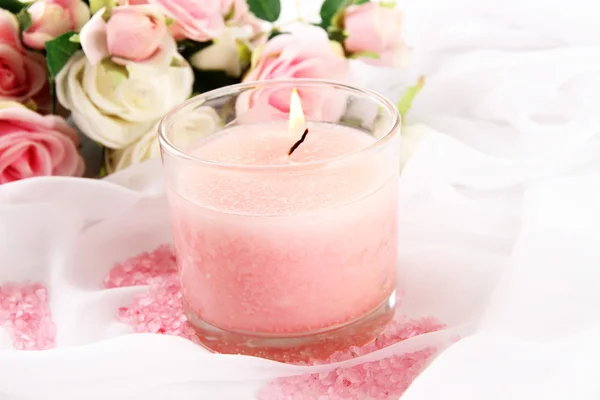 Beautiful candle with flowers on white cloth, close up — Stock Photo, Image