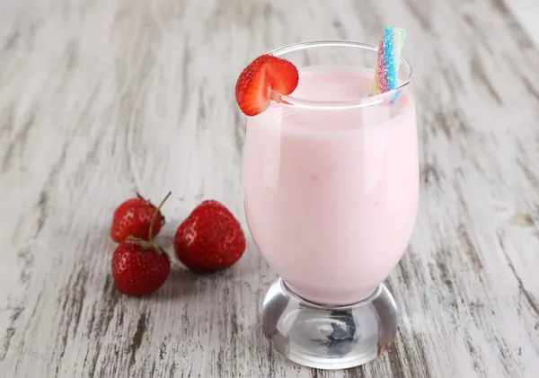 Delicious milk shake with strawberries on wooden table close-up — Stock Photo, Image