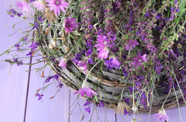 Wild flowers, on wicker mat, on color wooden background — Stock Photo, Image