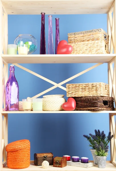 Prateleiras brancas bonitas com diferentes objetos relacionados com a casa, no fundo da parede de cor — Fotografia de Stock