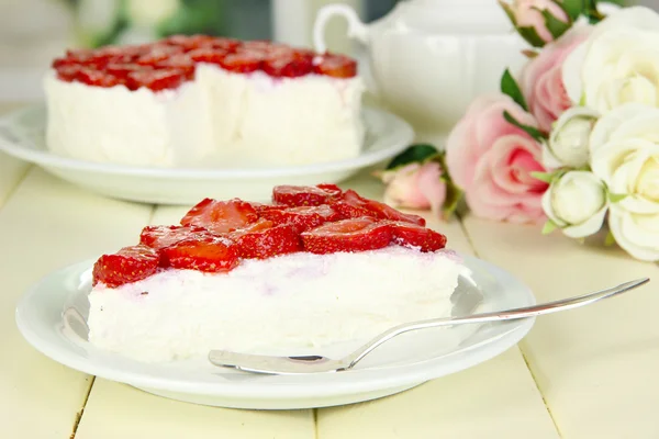 Cheesecake met verse aardbeien op witte plaat op houten tafel — Stockfoto