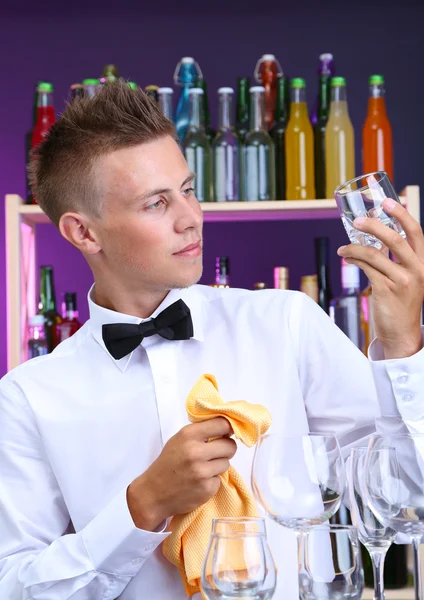 Bartender wipes glasses at work — Stock Photo, Image