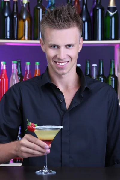 Portrét hezký barman připravuje koktejlu v baru — Stock fotografie