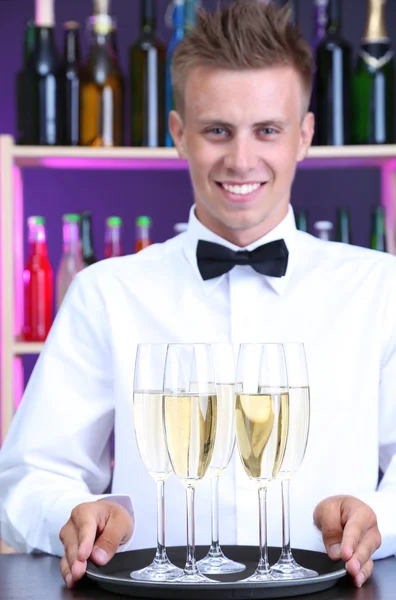 Bartender holding tray with champagne glasses — Stock Photo, Image