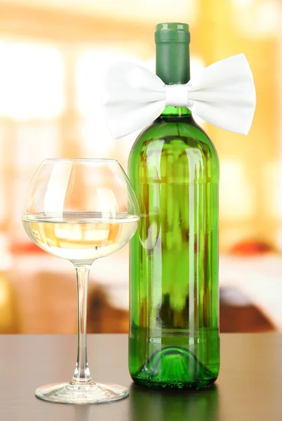 White bow tie on wine bottle on bright background — Stock Photo, Image