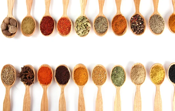 Assortment of spices in wooden spoons, isolated on white — Stock Photo, Image