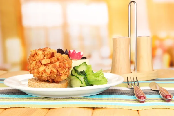 Chicken Kiev on croutons with lettuce salad, on wooden table, on bright background — Stock Photo, Image