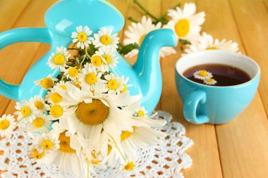 ahşap masa yakın çekim üzerinde çaydanlığın içinde güzel buket chamomiles