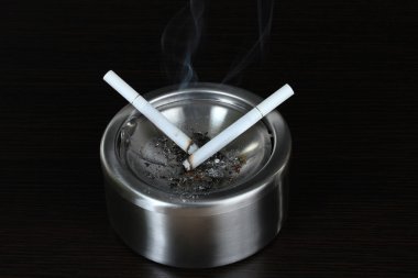 metal kül tablası ile sigara, siyah üzerine izole