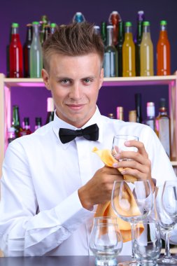 Barmen gözlük iş yerinde siliyor.