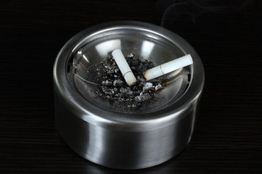 metal kül tablası ile sigara, siyah üzerine izole