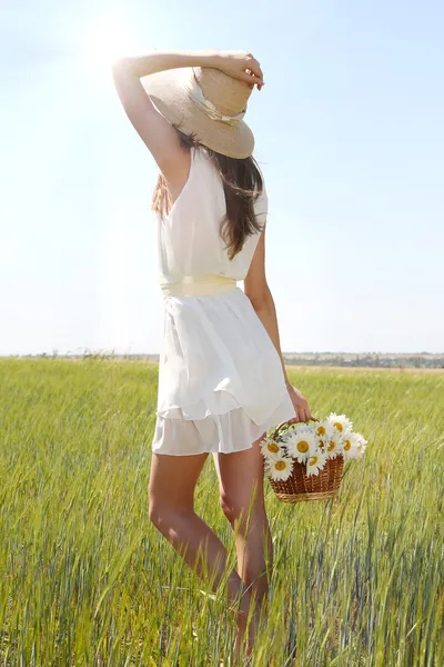 Porträt einer schönen jungen Frau mit Blumen auf dem Feld — Stockfoto