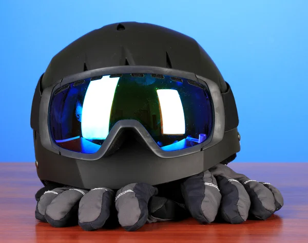 Kış spor gözlük, kask ve eldivenler, mavi zemin üzerine — Stok fotoğraf