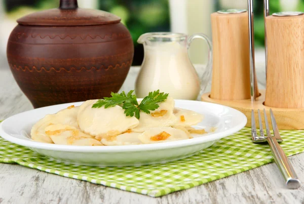 Gnocchi gustosi con cipolla fritta su piatto bianco, su sfondo brillante — Foto Stock