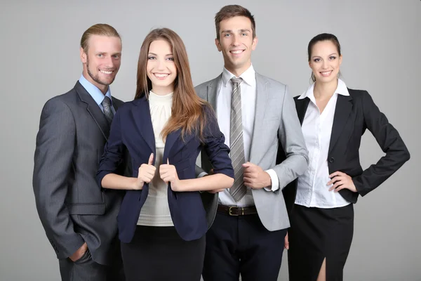 Business team standing in row on grey background — Stock Photo, Image