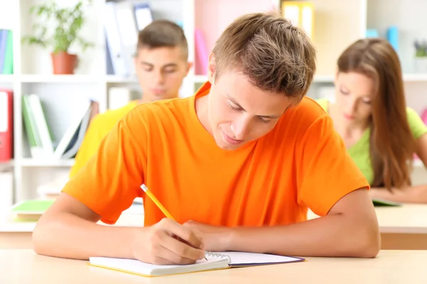 Grupa młodych studentów siedzi w bibliotece — Zdjęcie stockowe