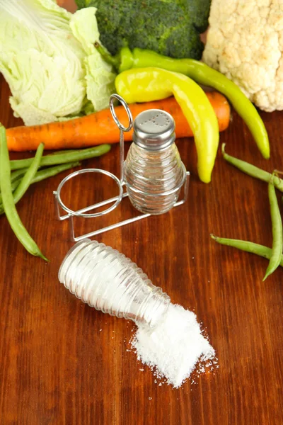 塩と胡椒ミルズと木製の背景上の新鮮な野菜の組成 — ストック写真