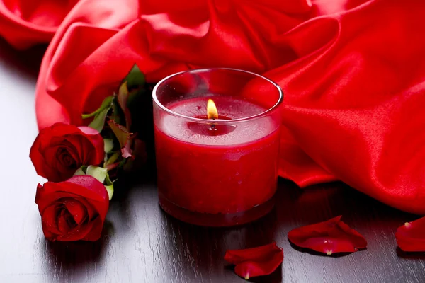 Bella candela rossa romantica con fiori e panno di seta, primo piano — Foto Stock