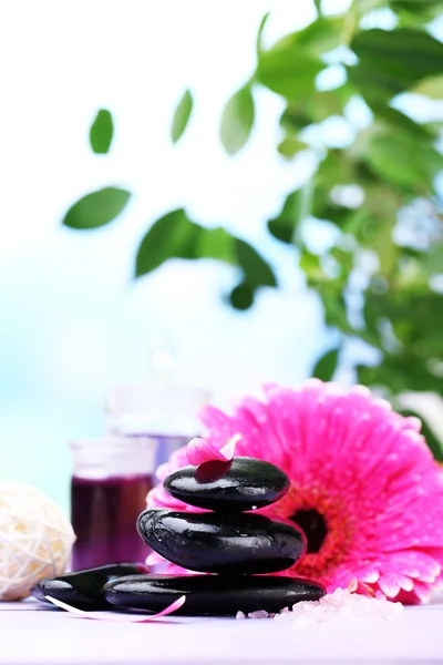 Spa stenen en mooie gerbera op houten tafel — Stockfoto