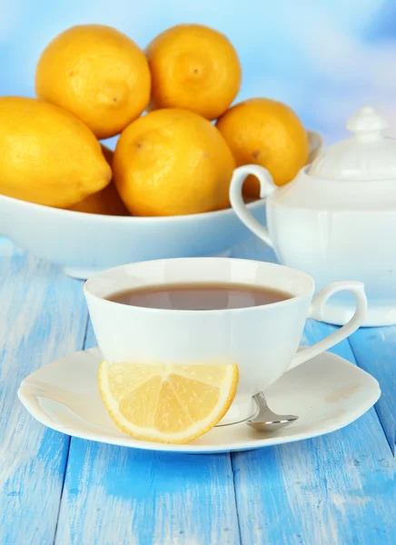 Tasse de thé au citron sur table sur fond bleu — Photo