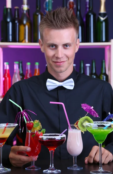 Portrait of handsome barman with different cocktails cocktail, at bar — Stock Photo, Image