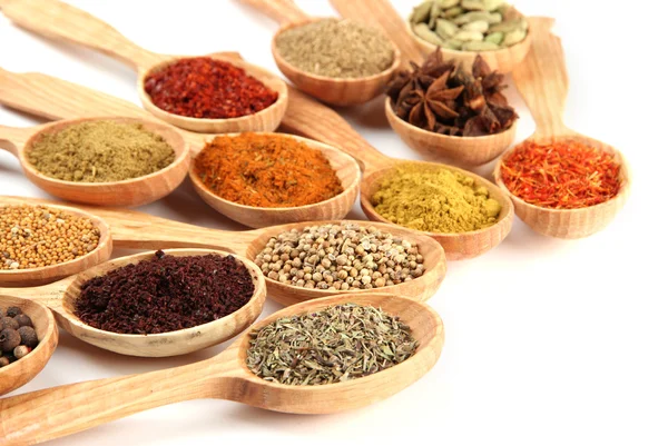 Tahta kaşıklardaki çeşitli baharatlar, beyaz kaşık üzerinde izole edilmiş.