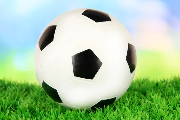 Soccer ball on green grass on bright background — Stock Photo, Image