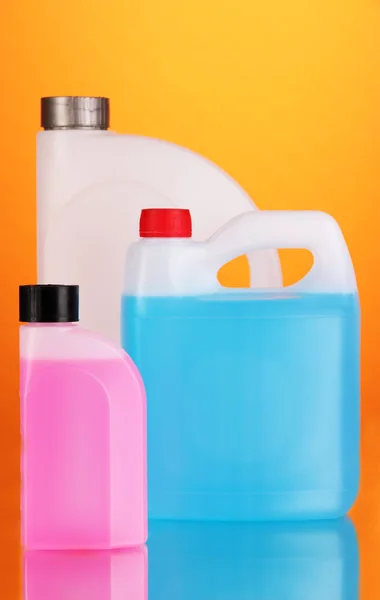 Liquids for car in canisters on orange background — Stock Photo, Image