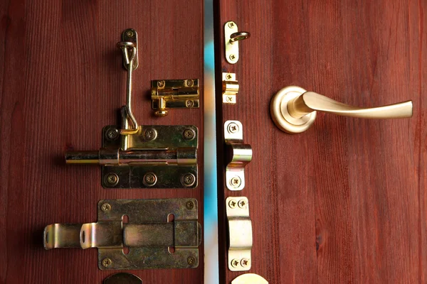 Parafusos metálicos, travas e ganchos em porta aberta de madeira close-up — Fotografia de Stock