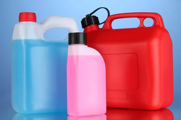 Liquidi per auto in contenitori su sfondo blu — Foto Stock