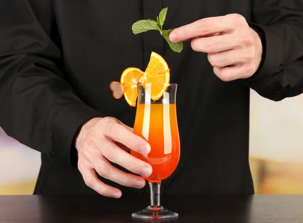 Bartender making and decorating cocktail on bright background, close-up — Stock Photo, Image