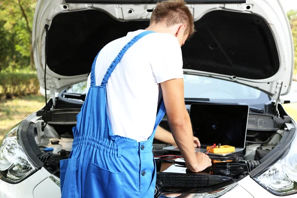 Mecánico profesional de automóviles que trabaja en el servicio de reparación de automóviles —  Fotos de Stock
