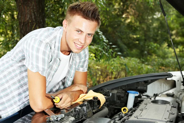 Młody kierowca naprawy silnika samochodu na zewnątrz — Zdjęcie stockowe
