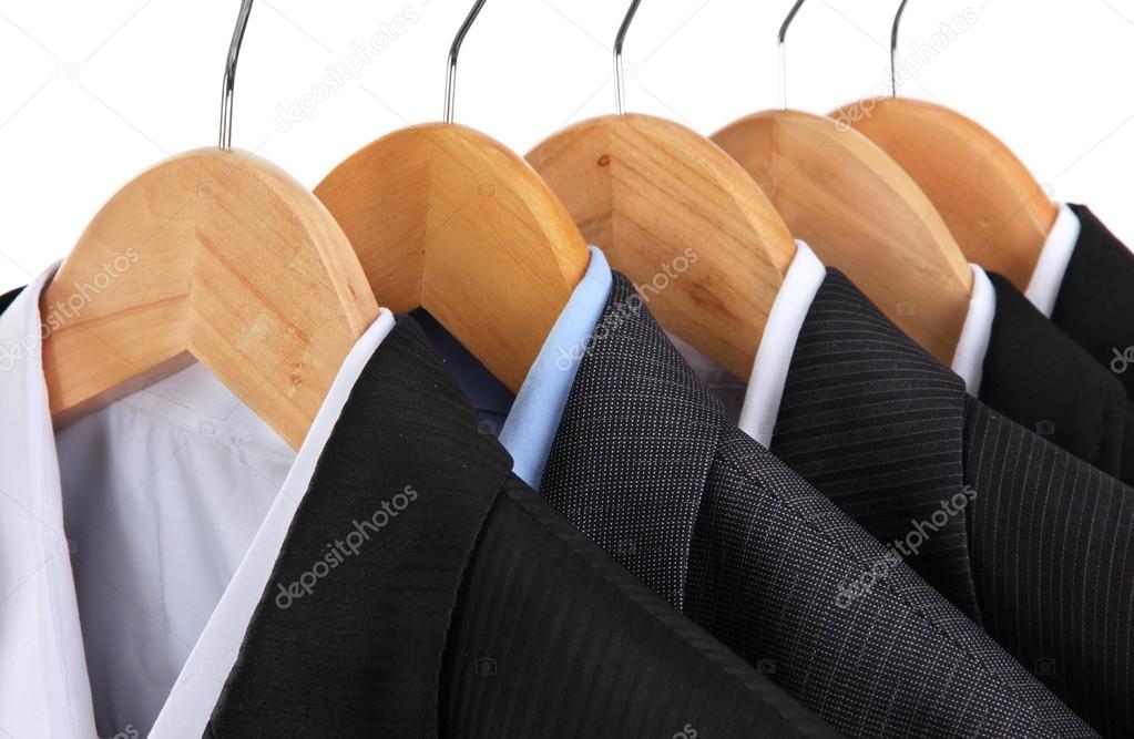 Suits with shirts on hangers on white background