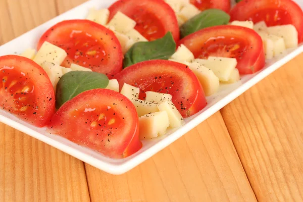 Cheese mozzarella with vegetables in plate on table — Stock Photo, Image