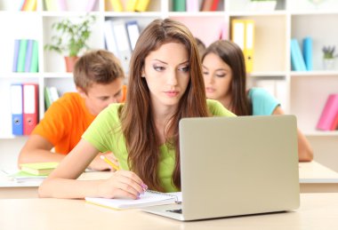 Kütüphanede oturan genç öğrenci grubu