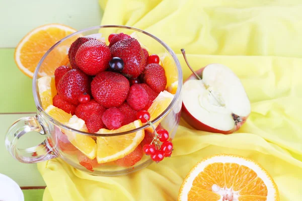 Nützlicher Obstsalat im Glasbecher auf Holztisch in Großaufnahme — Stockfoto