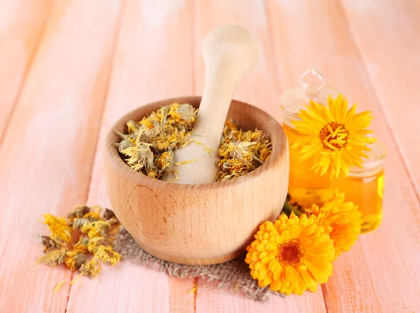 ilaç şişeleri ve ahşap zemin üzerine calendula çiçekler