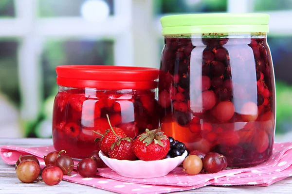 Huisgemaakte berry jam op houten tafel op achtergrond van venster — Stockfoto