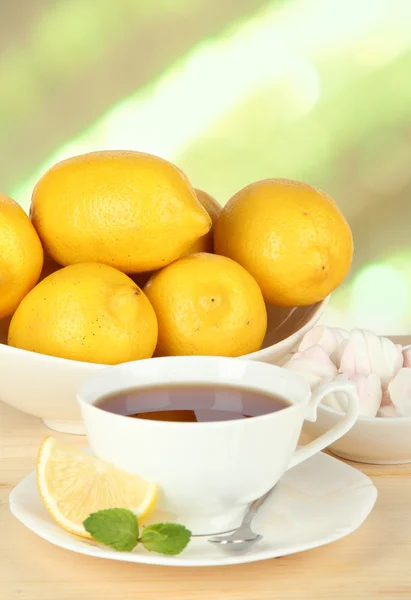Taza de té con limón sobre la mesa sobre fondo claro —  Fotos de Stock