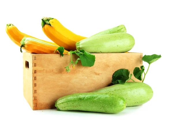 Raw yellow and green zucchini in wooden crate, isolated on white — Stock Photo, Image