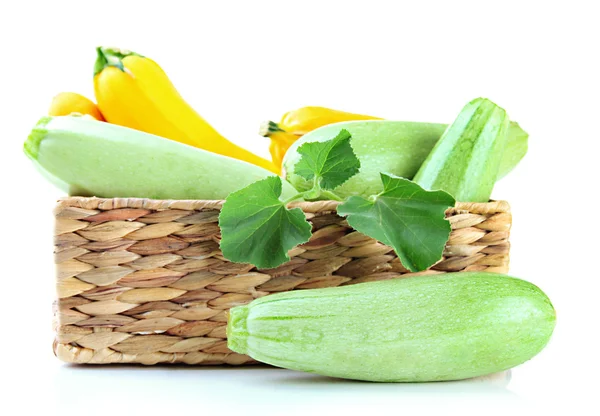 Rohe gelbe und grüne Zucchini in Weidenkiste, isoliert auf weiß — Stockfoto