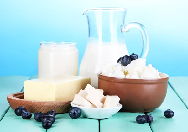 Fresh dairy products with blueberry on wooden table on natural background — Stock Photo, Image