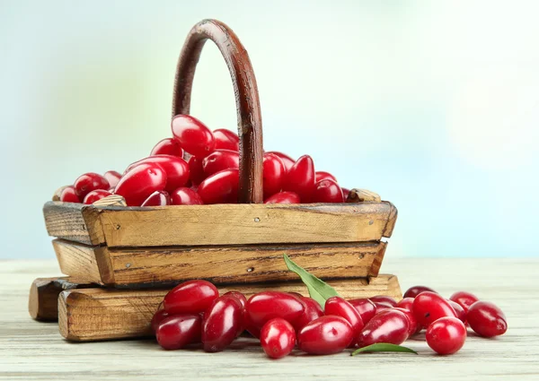 Fresh cornel berries in basket on wooden table — Stock Photo, Image