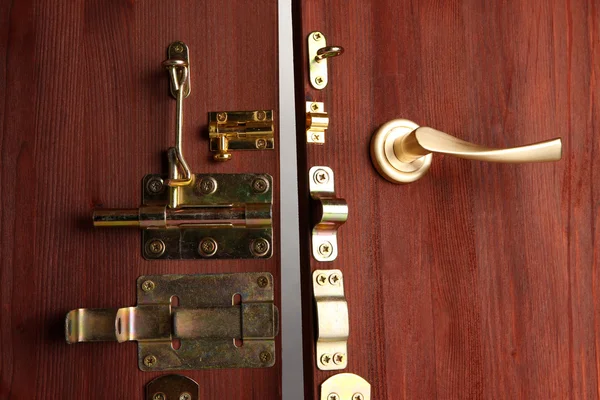 Parafusos metálicos, travas e ganchos em porta aberta de madeira close-up — Fotografia de Stock