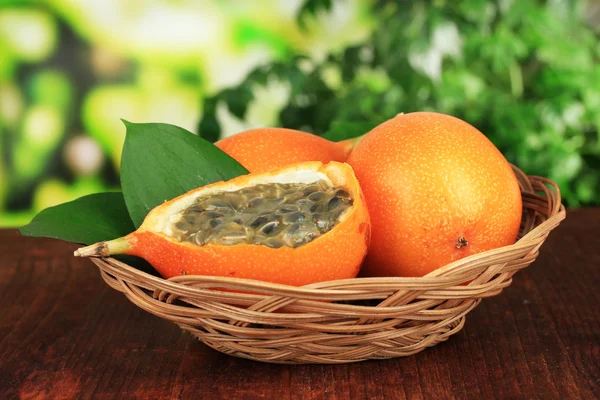 Passion fruits in wicker basket on table on bright background — Stock Photo, Image