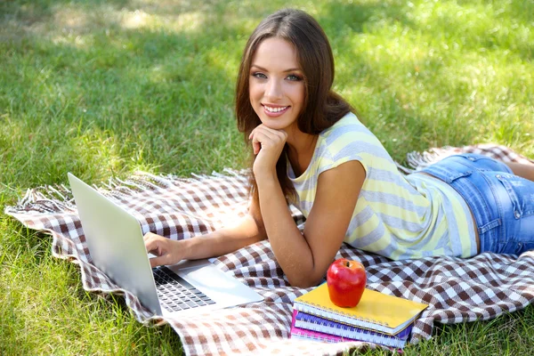 Vacker ung flicka med laptop i park — Stockfoto