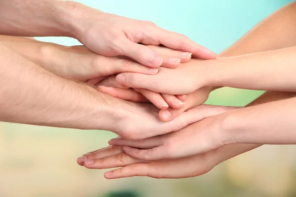 Mani unite su sfondo luminoso. Foto concettuale del lavoro di squadra — Foto Stock