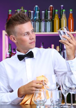 Barmen gözlük iş yerinde siliyor.